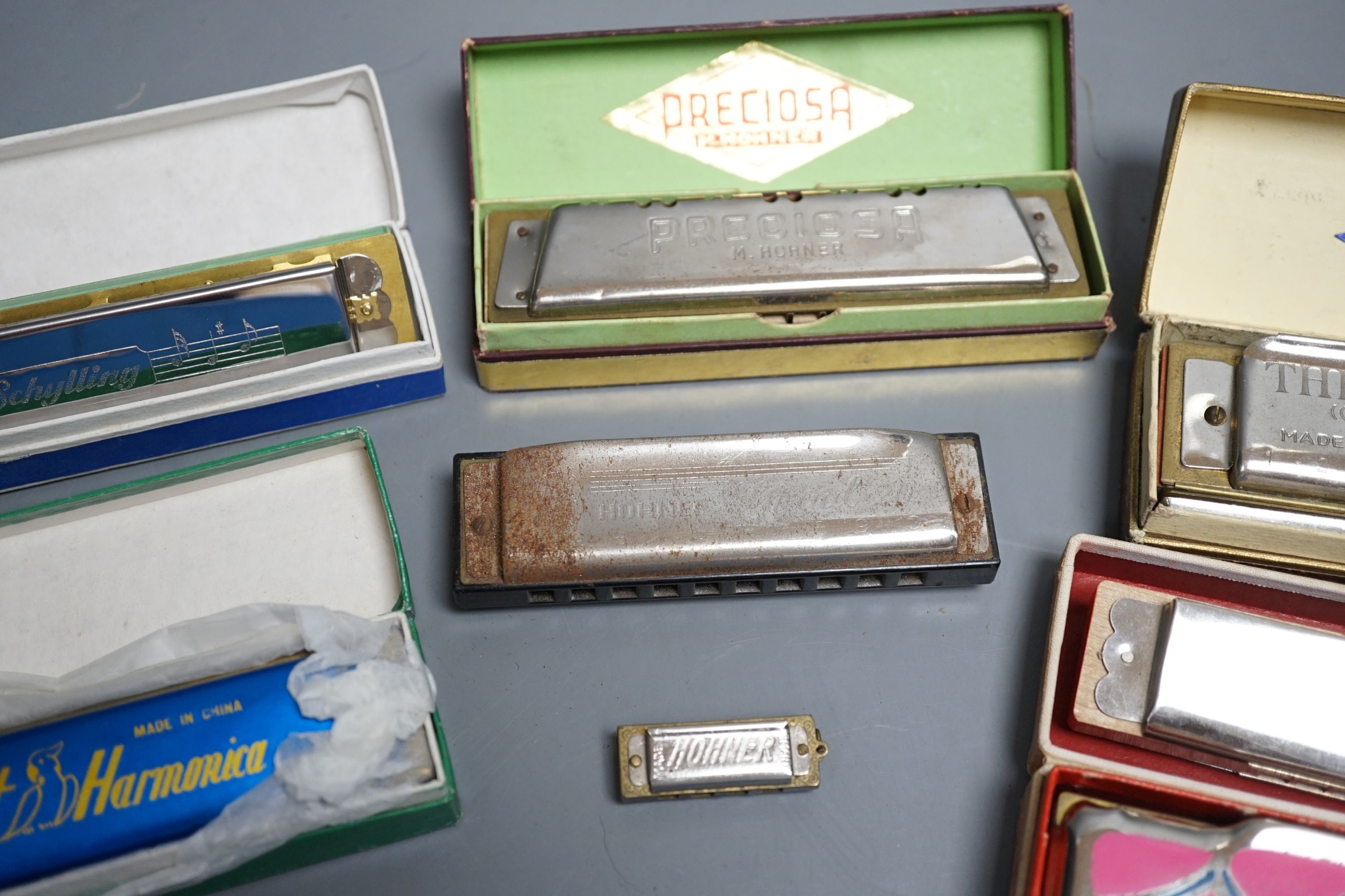 Eight various harmonicas, some with boxes